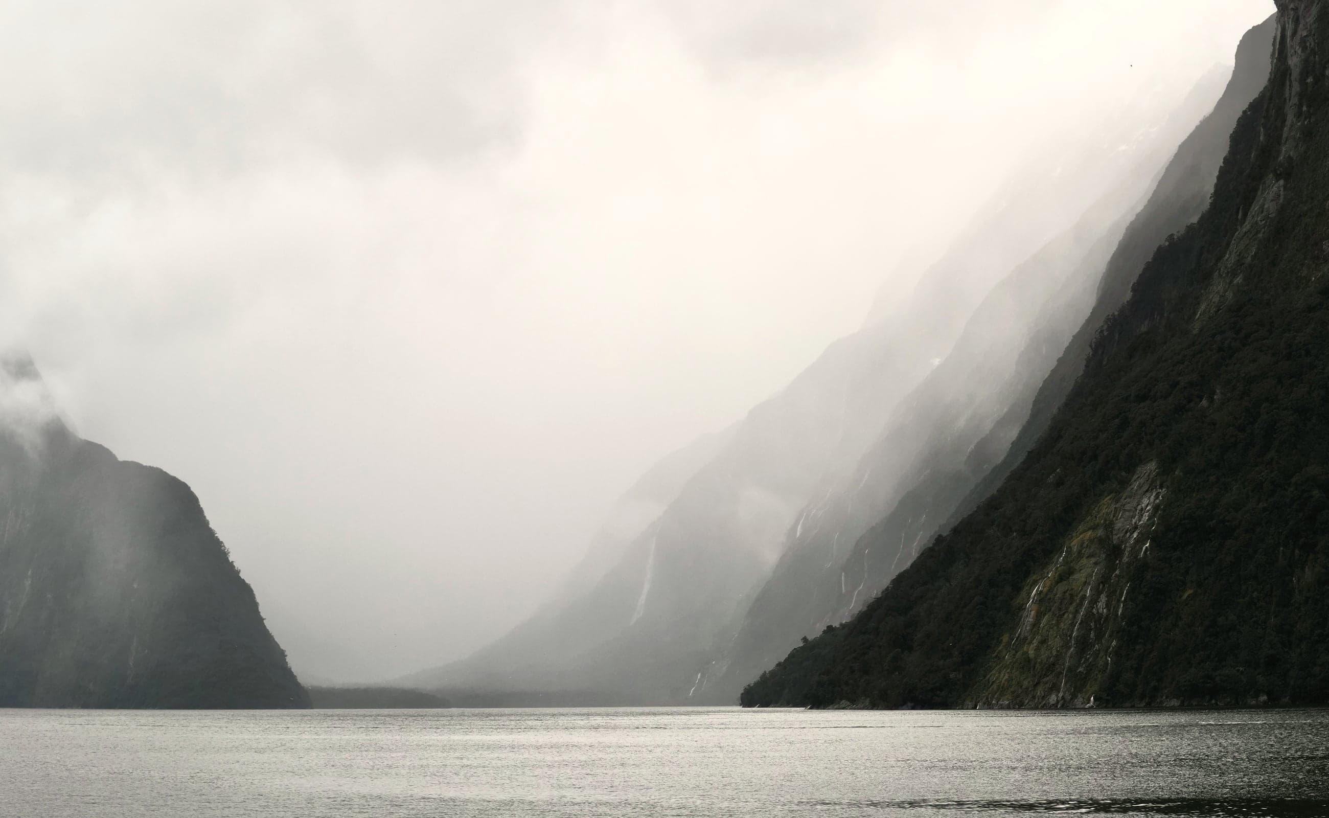 Mist lifting off still water between steep cliffs